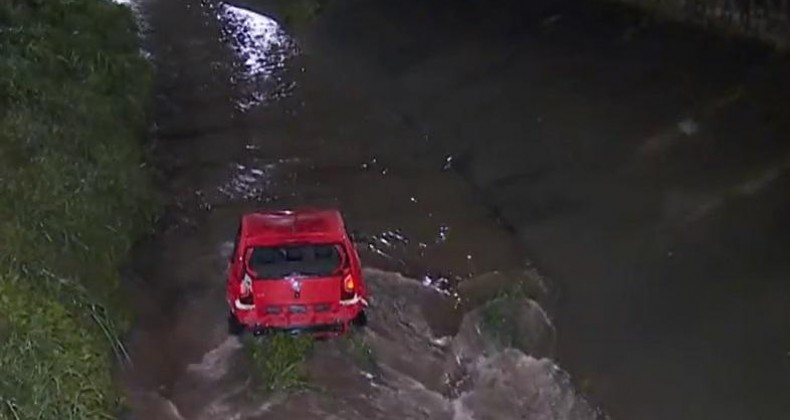 Homem desaparece durante temporal após carro capotar e cair em rio.